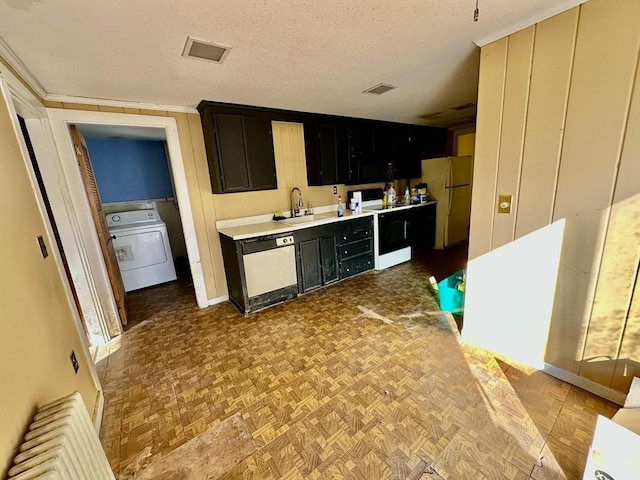 kitchen with sink, washer / clothes dryer, a textured ceiling, white appliances, and light parquet flooring