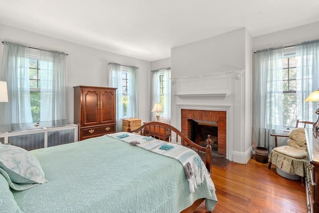 18 Milton Rd, Brookline, MA 02445 - bedroom featuring wood-type flooring and a brick fireplace