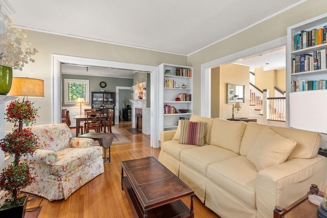 18 Milton Rd, Brookline, MA 02445 - living area with a brick fireplace, wood finished floors, crown molding, and stairs