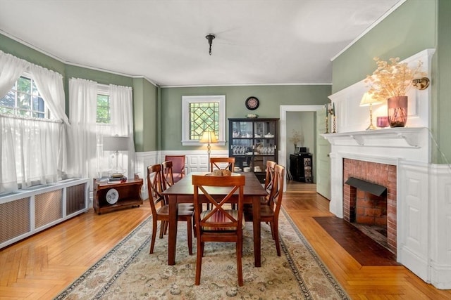 18 Milton Rd, Brookline, MA 02445 - dining room featuring crown molding, a brick fireplace, radiator heating unit, and wainscoting