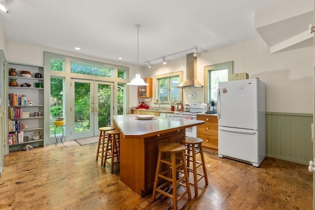 18 Milton Rd, Brookline, MA 02445 - kitchen with white appliances, wall chimney range hood, french doors, a kitchen bar, and a wainscoted wall