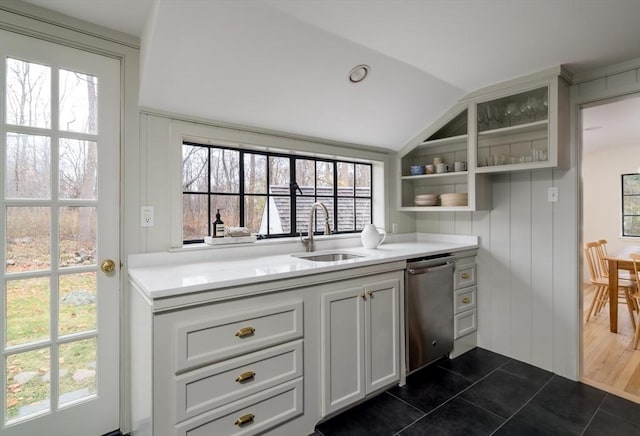 kitchen with vaulted ceiling, dishwasher, dark tile patterned flooring, plenty of natural light, and sink