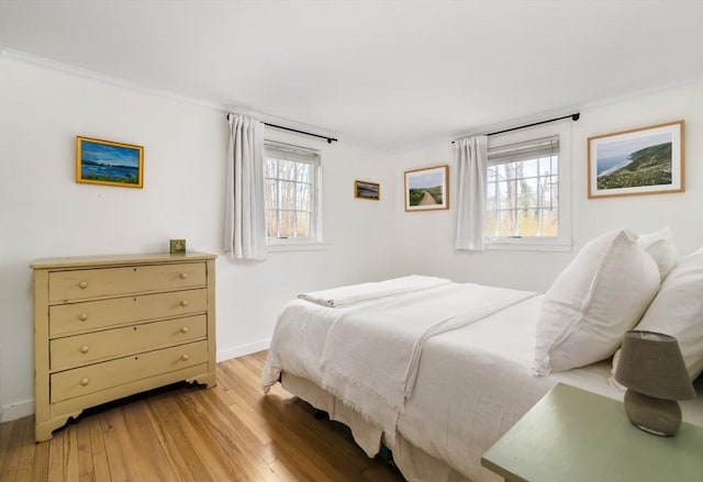 bedroom featuring ornamental molding and light hardwood / wood-style flooring