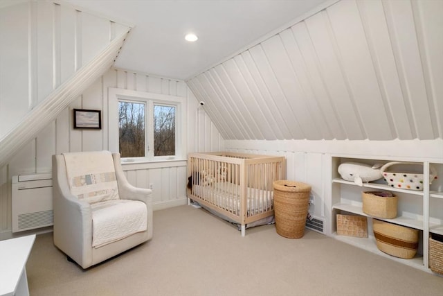 bedroom featuring light carpet, a crib, and lofted ceiling