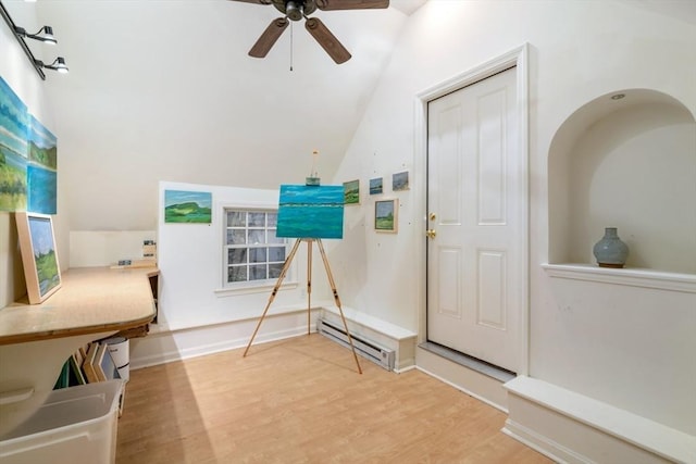 entryway with hardwood / wood-style flooring, a baseboard heating unit, ceiling fan, and vaulted ceiling