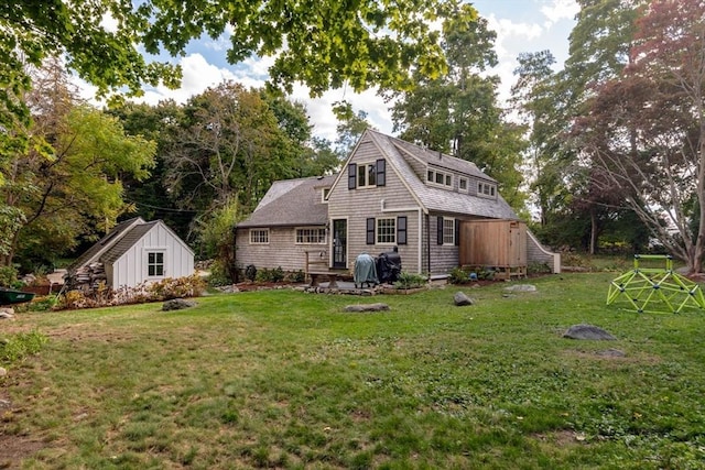 rear view of house with a storage unit and a lawn