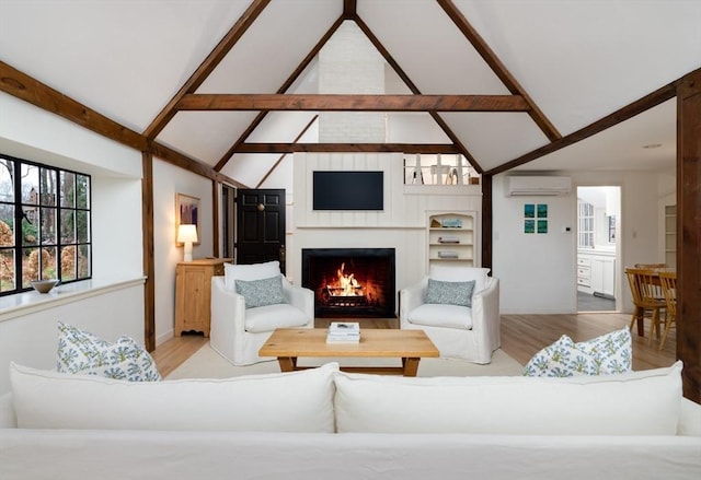 living room with light hardwood / wood-style floors, a wall mounted AC, and lofted ceiling with beams