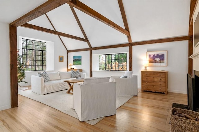 living room with high vaulted ceiling, a fireplace, a healthy amount of sunlight, and beam ceiling