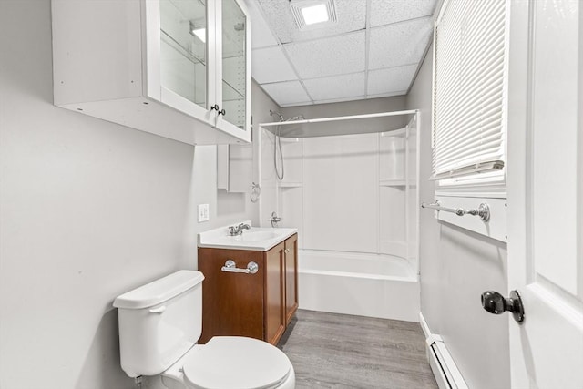 full bathroom featuring hardwood / wood-style floors, washtub / shower combination, vanity, toilet, and a drop ceiling