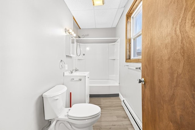 full bathroom featuring a baseboard radiator, vanity, toilet, hardwood / wood-style flooring, and  shower combination