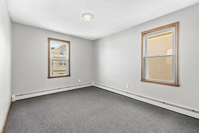 carpeted spare room featuring a textured ceiling and a baseboard heating unit