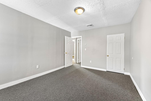 carpeted spare room featuring a textured ceiling