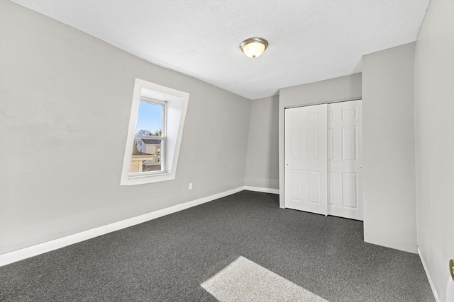 unfurnished bedroom with a closet and dark carpet