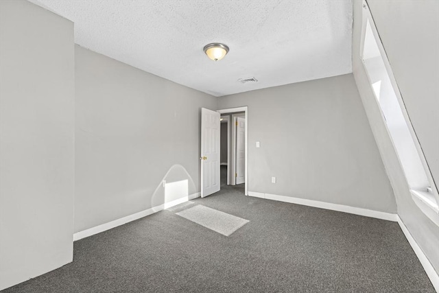 carpeted spare room featuring a textured ceiling