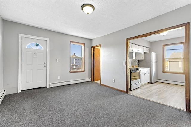 carpeted foyer entrance with a baseboard radiator, a textured ceiling, and sink