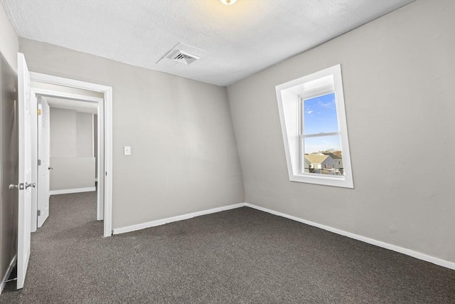 carpeted empty room featuring a textured ceiling