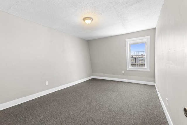 carpeted empty room featuring a textured ceiling