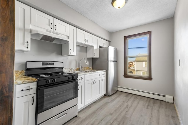 kitchen featuring light stone countertops, a baseboard radiator, white cabinets, and stainless steel appliances