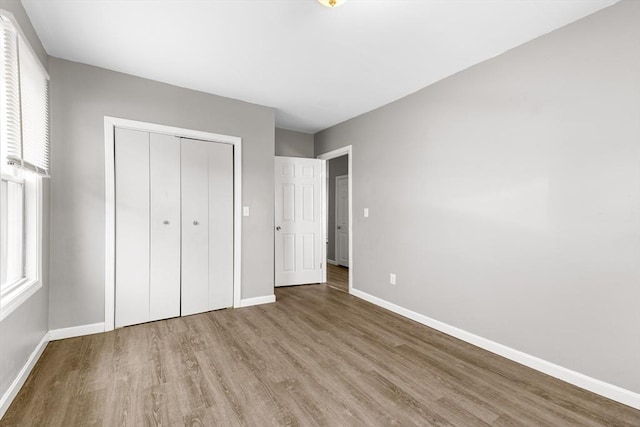 unfurnished bedroom featuring light wood-type flooring and a closet