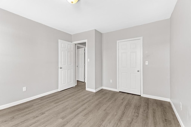 unfurnished bedroom featuring light wood-type flooring and a closet