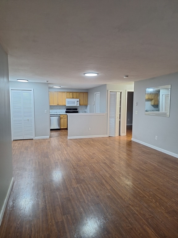 unfurnished living room featuring dark wood-type flooring