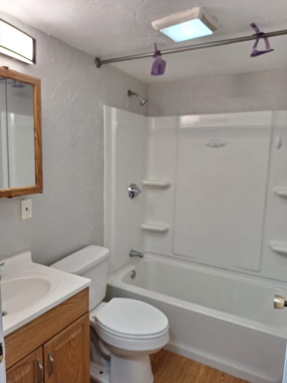 full bathroom with vanity, hardwood / wood-style floors, toilet, and bathing tub / shower combination