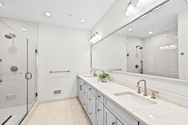 full bathroom featuring a sink, baseboards, a shower stall, and double vanity