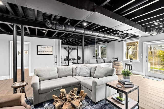 living area with baseboards, wood finished floors, and a wealth of natural light