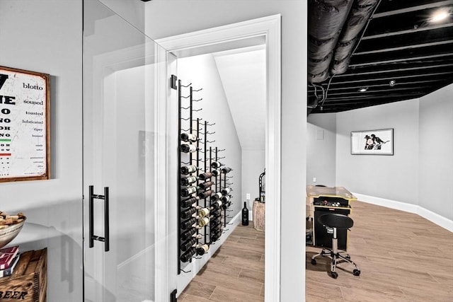 wine cellar with baseboards and light wood-style flooring