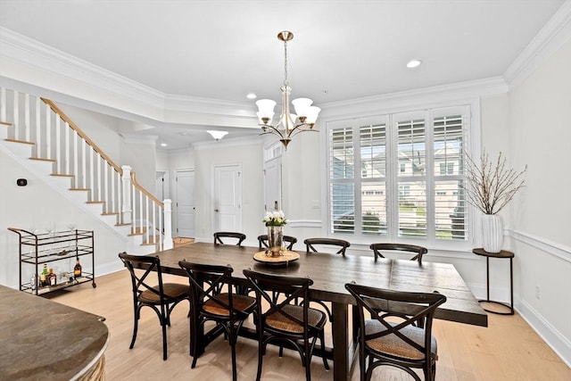 dining room featuring crown molding, an inviting chandelier, stairs, baseboards, and light wood-style flooring