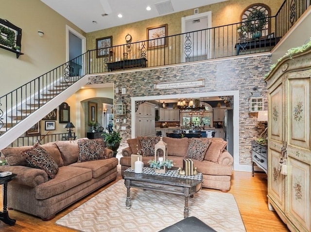 101 Colonial Dr Unit 101, Sturbridge, MA 01566 - living room featuring a towering ceiling, light wood-style flooring, arched walkways, stairway, and recessed lighting