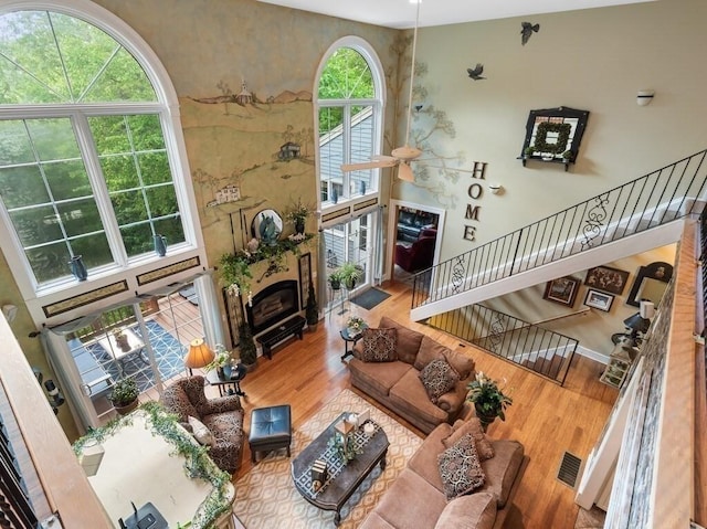 101 Colonial Dr Unit 101, Sturbridge, MA 01566 - living area with wood finished floors, a glass covered fireplace, and stairway