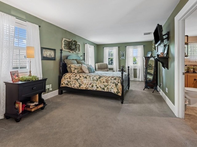 101 Colonial Dr Unit 101, Sturbridge, MA 01566 - bedroom with multiple windows, carpet floors, baseboards, and ensuite bath
