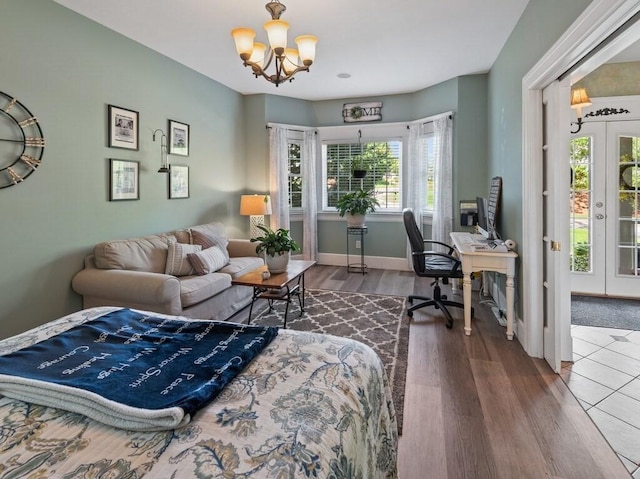 101 Colonial Dr Unit 101, Sturbridge, MA 01566 - bedroom with an office area, a chandelier, french doors, wood finished floors, and baseboards