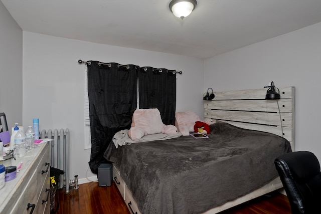 bedroom featuring radiator heating unit and dark wood-type flooring