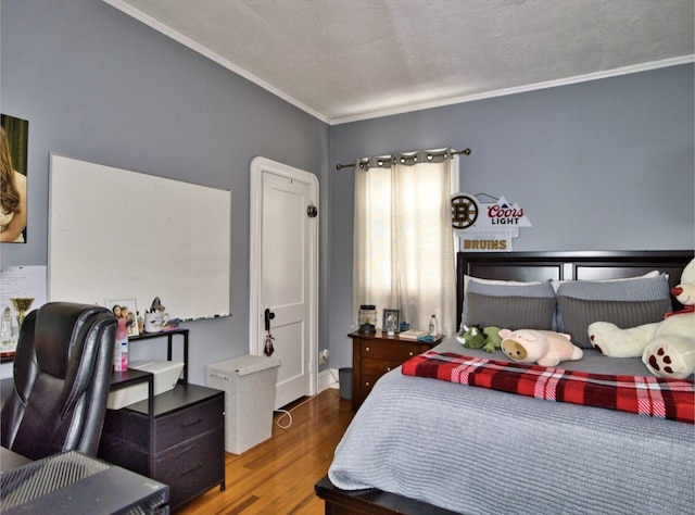 bedroom with a textured ceiling, crown molding, and wood-type flooring