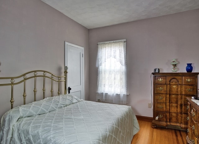 bedroom with hardwood / wood-style floors and a textured ceiling