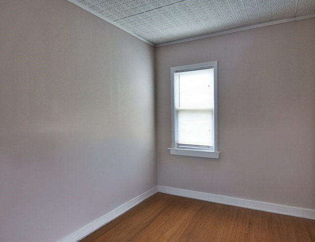 empty room featuring crown molding and hardwood / wood-style floors