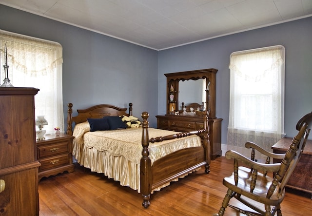 bedroom featuring ornamental molding and wood-type flooring