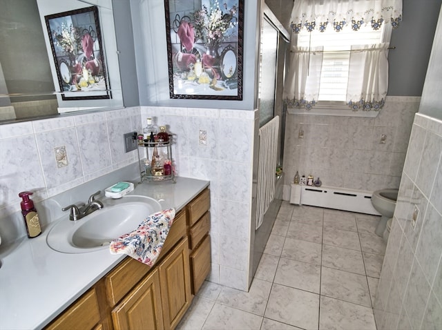 bathroom featuring toilet, tile walls, baseboard heating, vanity, and tile patterned flooring