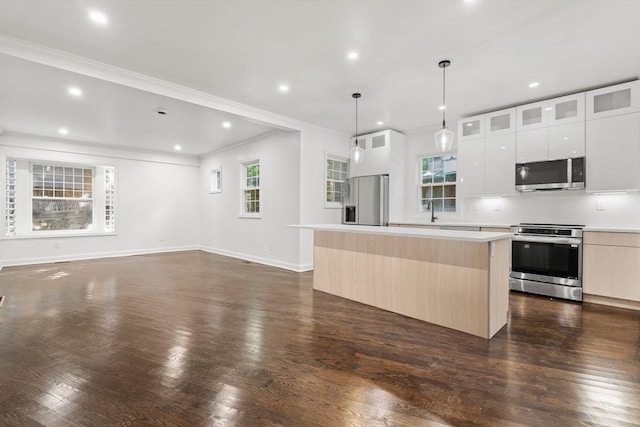 21 Greystone Rd Unit 2, Malden, MA 02148 - kitchen featuring appliances with stainless steel finishes, a kitchen island, ornamental molding, modern cabinets, and recessed lighting