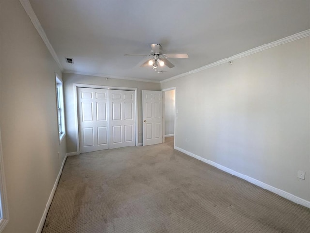 unfurnished bedroom featuring light carpet, baseboards, visible vents, ornamental molding, and a closet