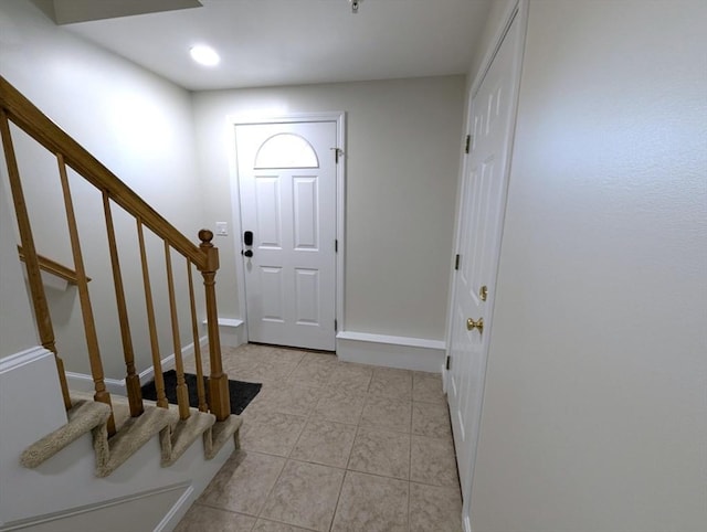 entryway featuring light tile patterned floors and stairs