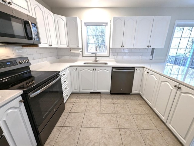 kitchen featuring stainless steel appliances, tasteful backsplash, a sink, and a healthy amount of sunlight