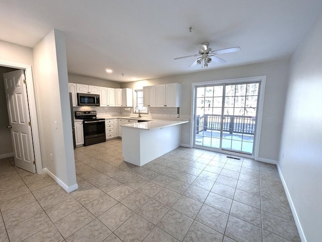 kitchen featuring visible vents, decorative backsplash, electric range oven, stainless steel microwave, and a peninsula