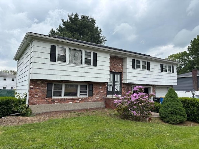 10 Gloversbrook Rd, Randolph, MA 02368 - raised ranch featuring brick siding, a front lawn, and an attached garage