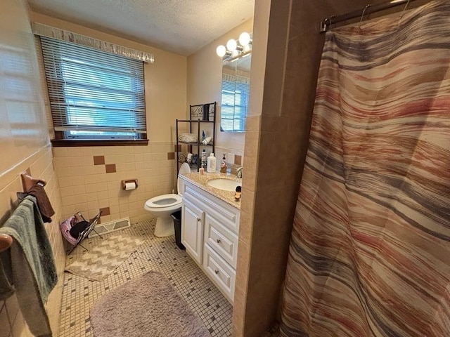 10 Gloversbrook Rd, Randolph, MA 02368 - full bath with vanity, a textured ceiling, tile walls, a shower with shower curtain, and tile patterned flooring
