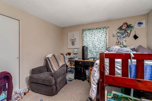 bedroom featuring a textured ceiling and carpet