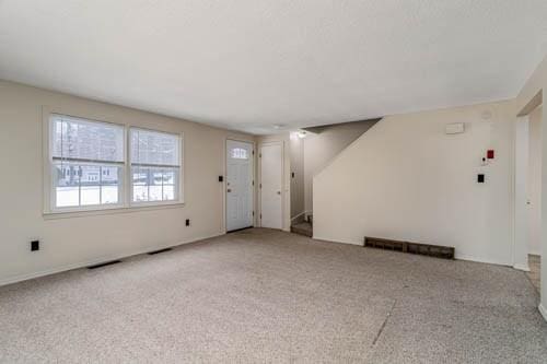 unfurnished living room featuring light carpet