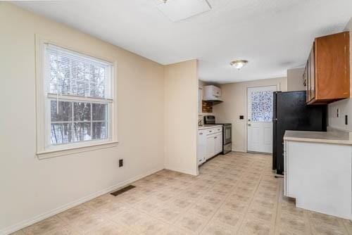 kitchen featuring black fridge and stainless steel electric range